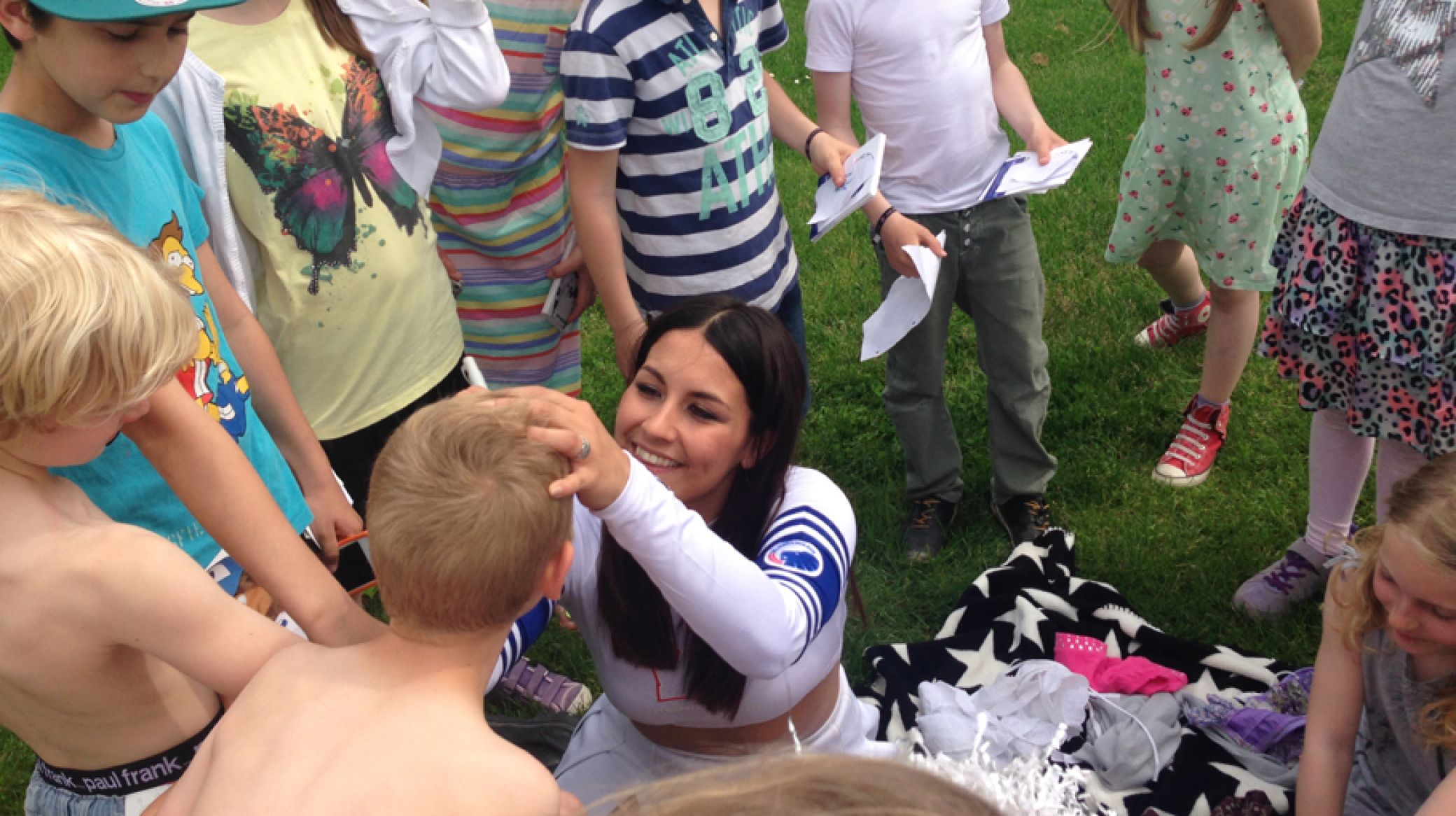Cheerleader fra Copenhagen White Cats skriver autografer på de små fans.