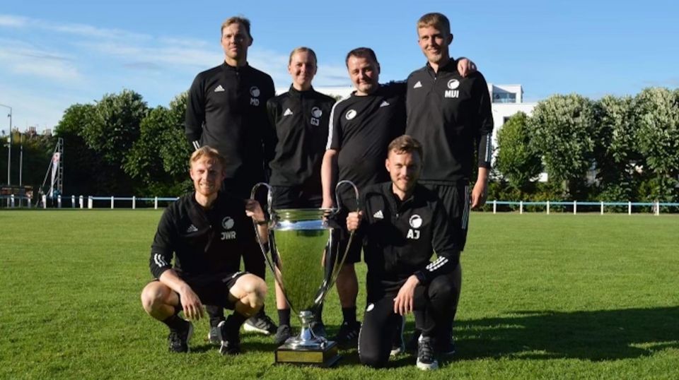 Staben omkring U17-holdet med pokalen i Frankrig