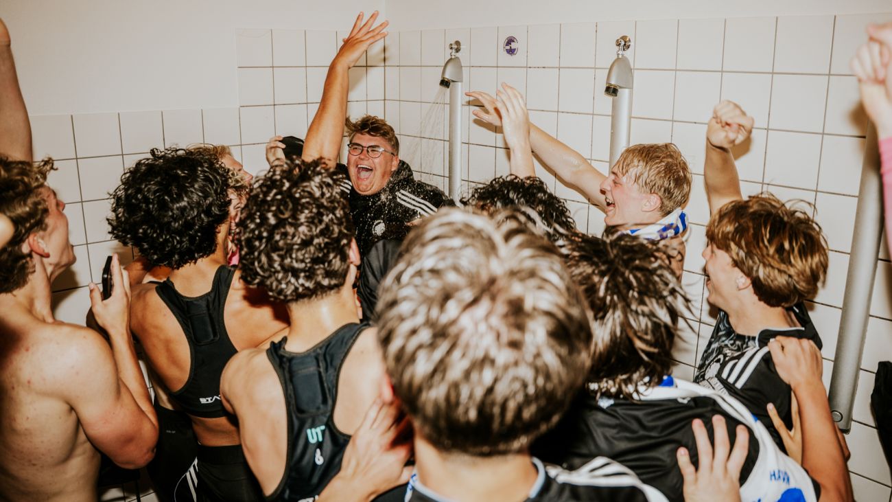 Analytiker Mikkel Pedersen får en tur under bruseren i U17's guldjubel