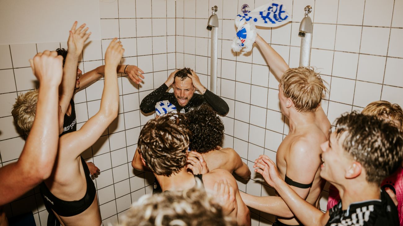 Assistenttræner Mathias Bonde får en tur under bruseren i U17's guldjubel
