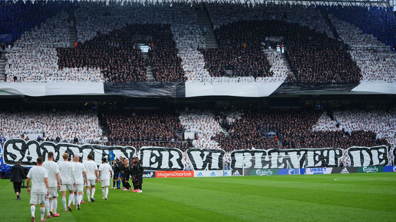 Spillerne går på banen foran Sektion 12-tifo